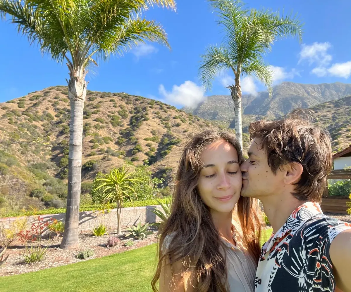 Julia and Wyatt in the garden in Ojai, palm trees and hills behind them